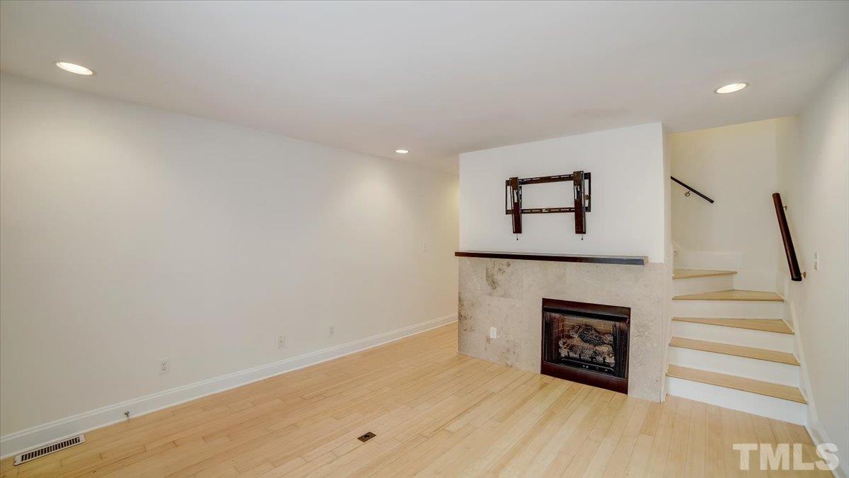 2504 Noble Road Raleigh, NC 27608 - Photo 6 of 28 a view of staircase with a fireplace and black walls