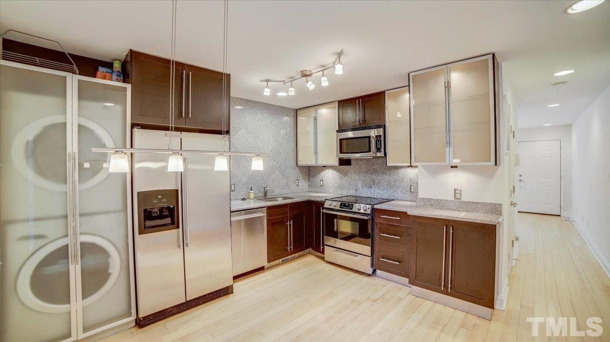 2504 Noble Road Raleigh, NC 27608 - Photo 8 of 28 a kitchen with stainless steel appliances granite countertop a sink and a refrigerator