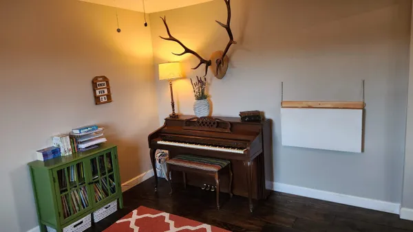 a dining area with furniture a chandelier and wooden floor