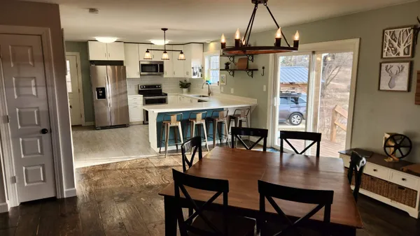 a dining room with furniture and a floor to ceiling window