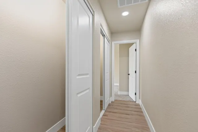 a view of a hallway with wooden floor