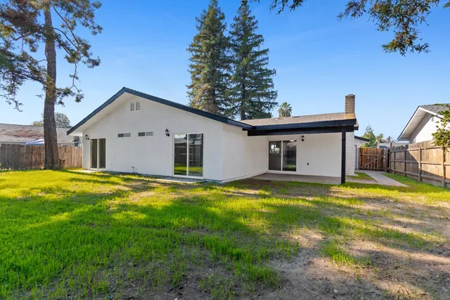 a view of a house with swimming pool and a yard