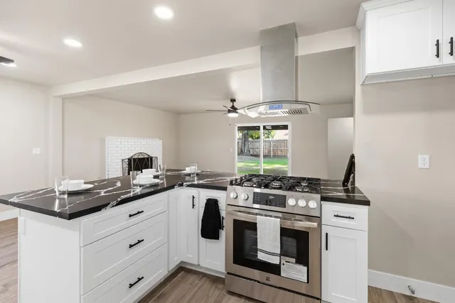 a kitchen with stainless steel appliances a stove a sink and a microwave