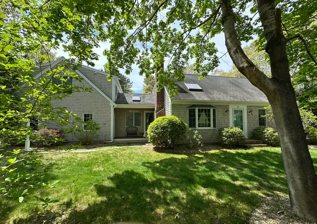 a view of a house with backyard and a tree