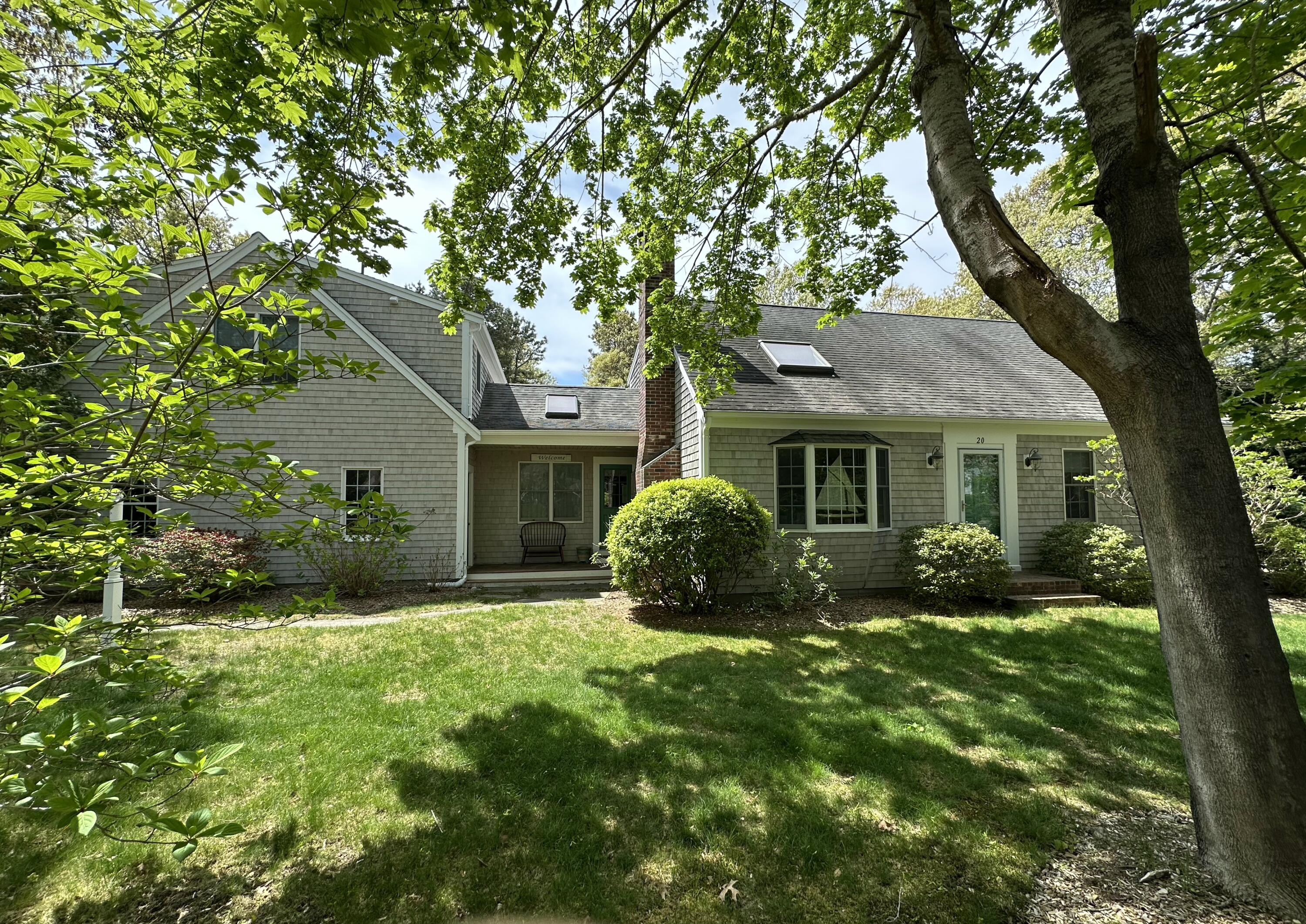 a view of a house with backyard and a tree