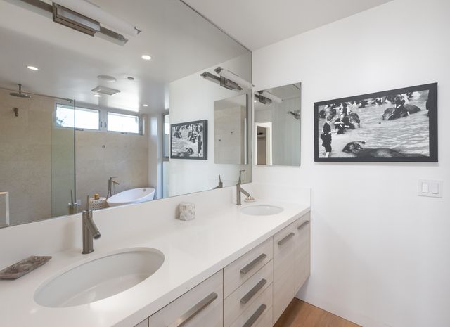a bathroom with double vanity sink and a mirror