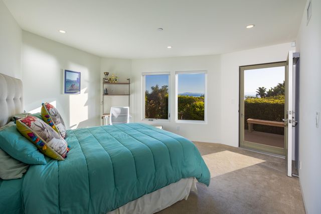 a bedroom with a bed and a large mirror