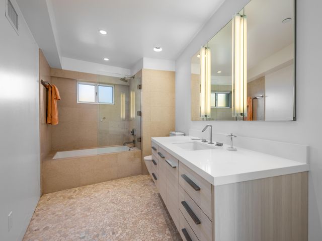 a bathroom with a tub sink and mirror