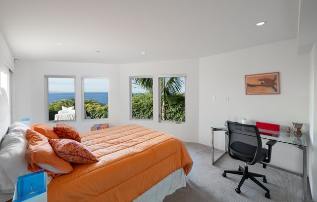 a bedroom with a bed chair and a large window