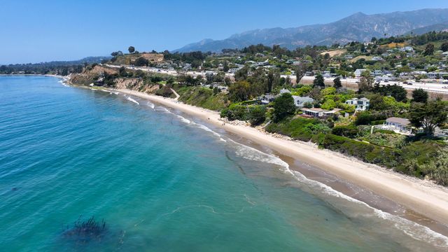 an aerial view of residential houses with outdoor space and trees