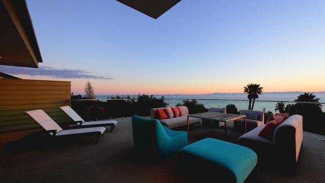 an outdoor living room with patio furniture and a potted plants