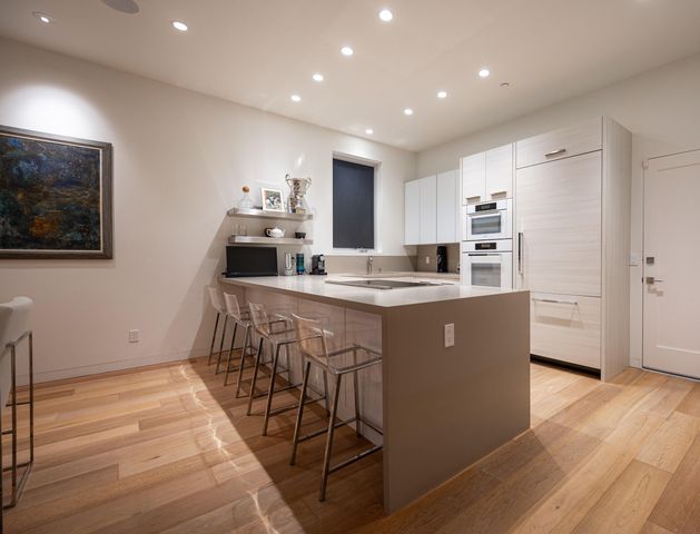 a kitchen with stainless steel appliances granite countertop a sink a stove a refrigerator and cabinets