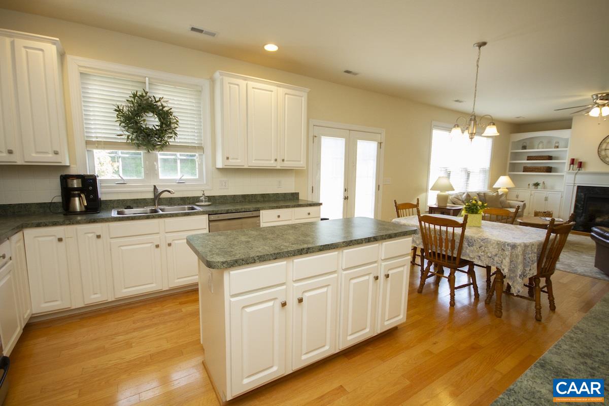 1380 Amber Ridge Road Charlottesville, VA 22901 - Photo 11 of 35 a kitchen with stainless steel appliances granite countertop a stove a sink dishwasher and white cabinets with wooden floor