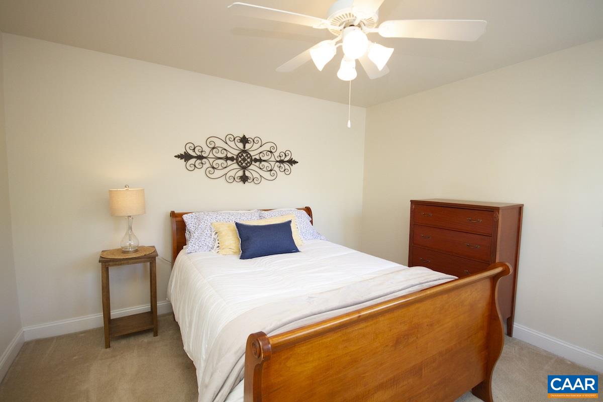 1380 Amber Ridge Road Charlottesville, VA 22901 - Photo 22 of 35 a bedroom with a bed and a chandelier