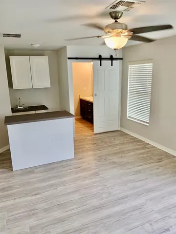 a view of a kitchen with wooden floor and a ceiling fan window