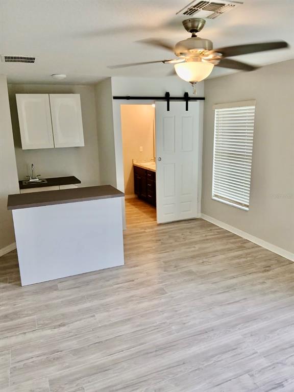 Undisclosed Address St. Cloud, FL 34772 - Photo 2 of 6 a view of a kitchen with wooden floor and a ceiling fan window
