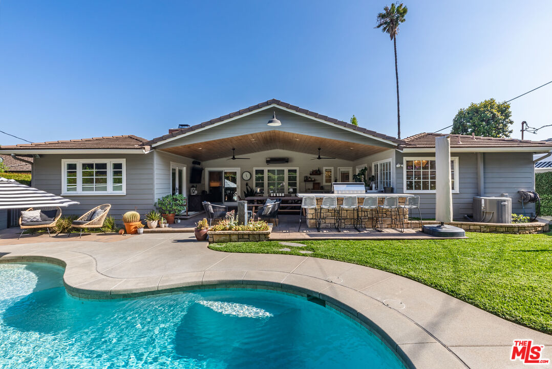 a view of a house with swimming pool and sitting area
