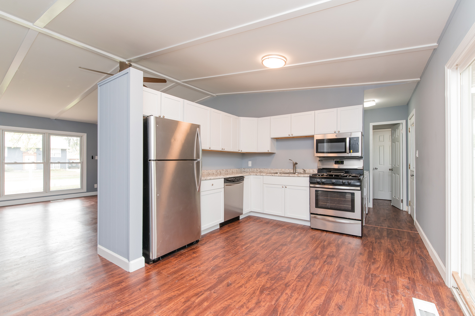 734 Surrey Drive Streamwood, IL 60107 - Photo 12 of 36 a kitchen with stainless steel appliances a refrigerator and a wooden floor