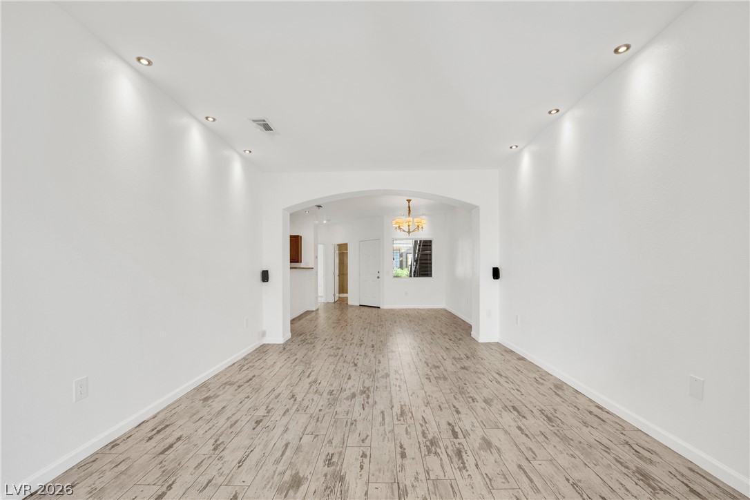 Recessed lighting illuminates wood-look tile flooring, creating an inviting, open-plan living space.