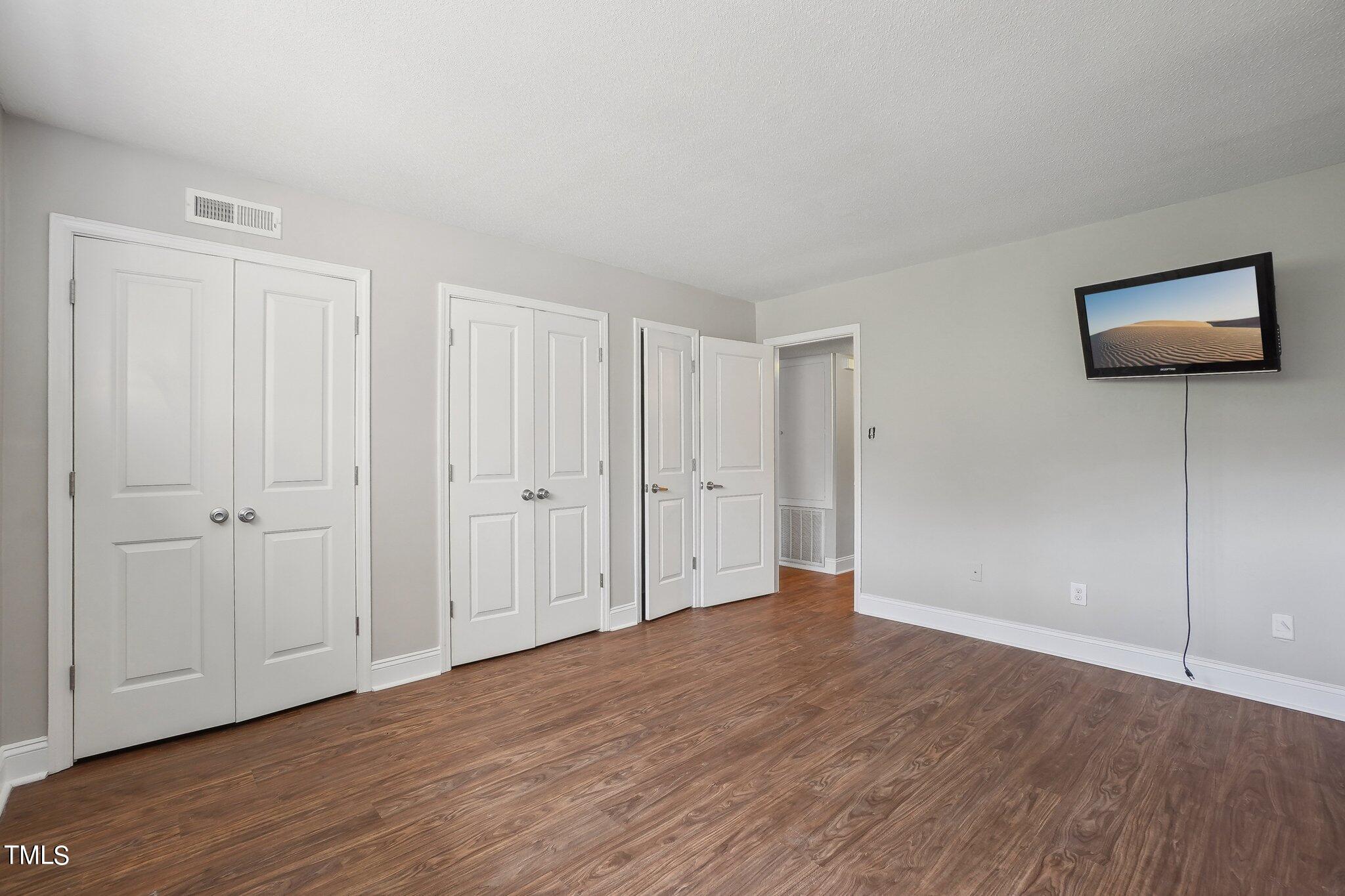 5104 Flint Ridge Place Raleigh, NC 27609 - Photo 13 of 16 a view of an empty room with wooden floor and closet