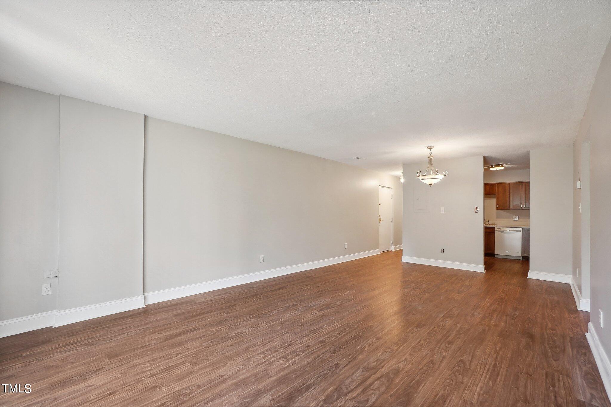 5104 Flint Ridge Place Raleigh, NC 27609 - Photo 7 of 16 a view of an empty room with wooden floor and a closet