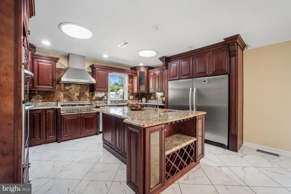 a kitchen with kitchen island granite countertop a stove a sink and a refrigerator