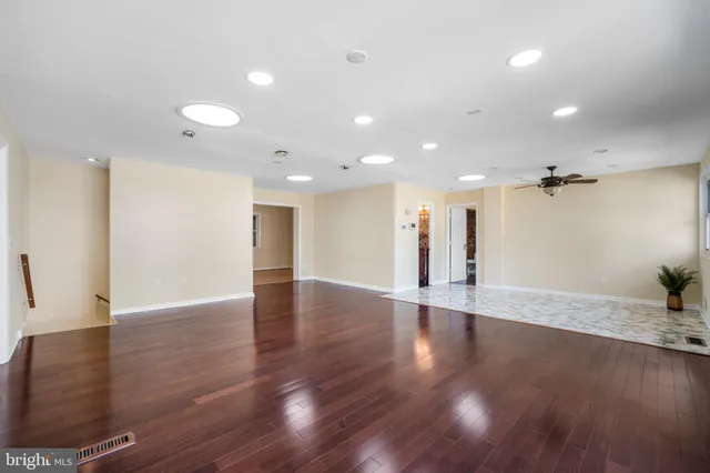 a view of an empty room with wooden floor and a cabinet