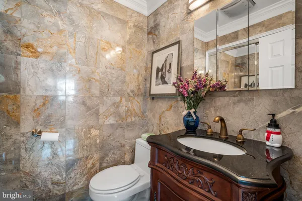 a bathroom with a granite countertop sink a toilet and shower