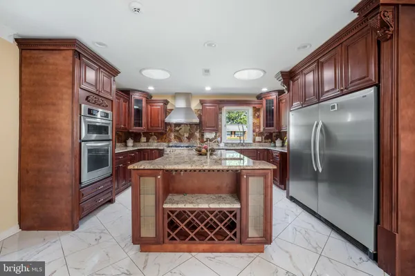 a kitchen with stainless steel appliances granite countertop a stove a refrigerator and a wooden cabinets