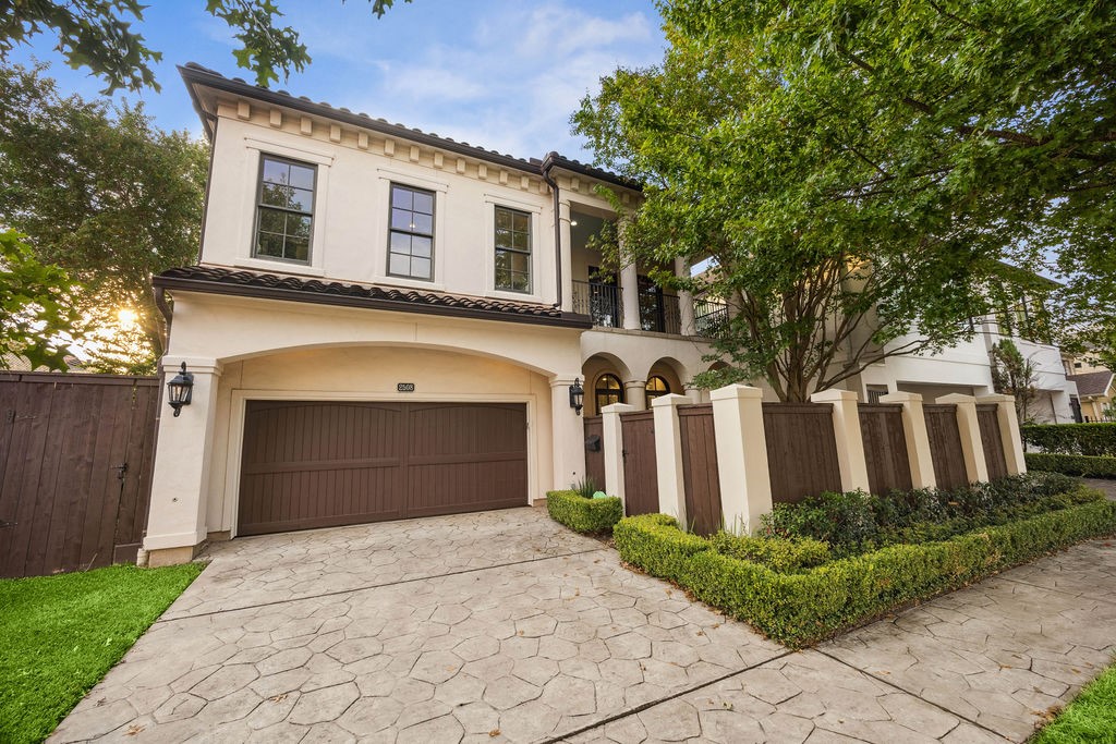 2508 Brun Street Houston, TX 77019 - Photo 2 of 50 This elegant two-story home features a stucco exterior with a Spanish-style tile roof. The property boasts a spacious double garage and a well-maintained front yard with lush greenery and a paved driveway. A charming balcony overlooks the entrance, providing a touch of sophistication.