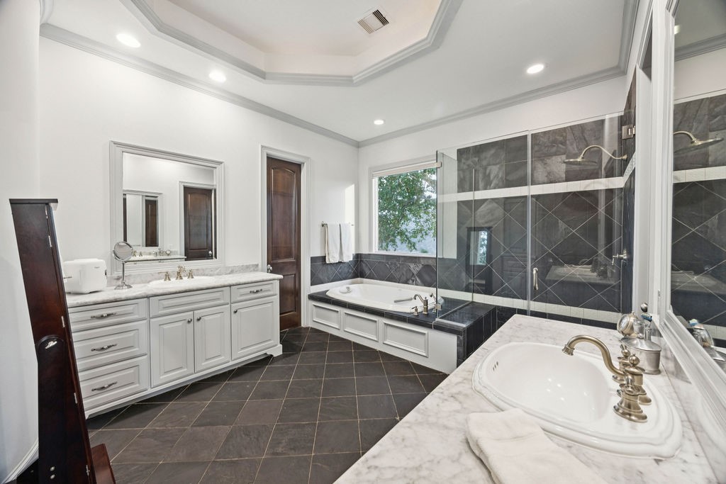 2508 Brun Street Houston, TX 77019 - Photo 34 of 50 This spacious bathroom features a luxurious soaking tub, a large glass-enclosed shower, and dual sinks with elegant fixtures. It has a modern design creates a bright, airy atmosphere.