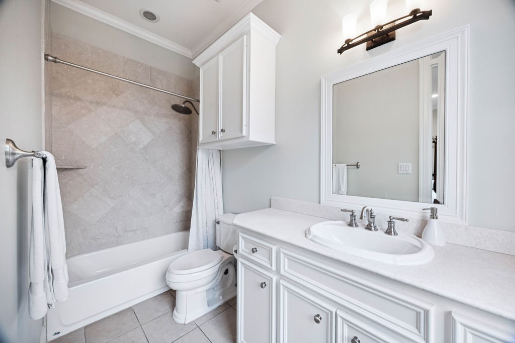 2508 Brun Street Houston, TX 77019 - Photo 43 of 50 This bathroom features a clean and modern design with a white vanity, ample cabinet storage, and a large mirror. It includes a bathtub with a tiled shower area and elegant fixtures, offering a bright and fresh space.