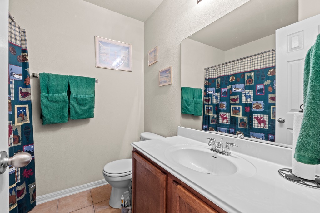 12008 Lansdowne Road Austin, TX 78754 - Photo 22 of 29 A well-appointed bathroom offers a practical vanity, toilet, and shower with tiled flooring.