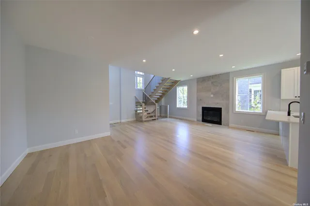a view of empty room with wooden floor and a fireplace