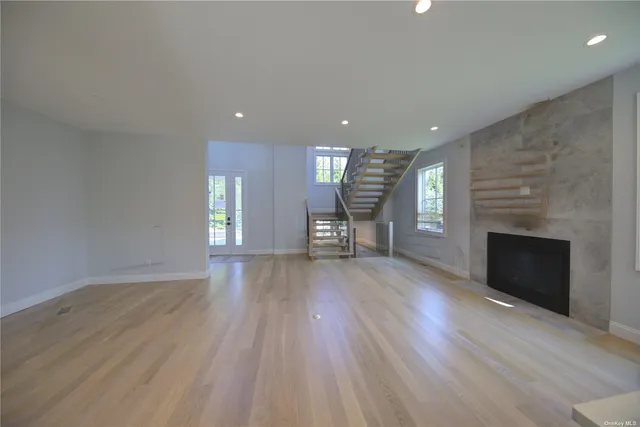 an empty room with wooden floor and fireplace