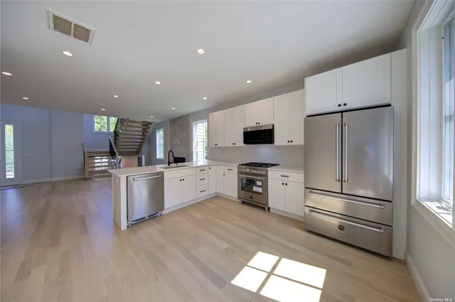 a kitchen with stainless steel appliances a refrigerator sink and microwave
