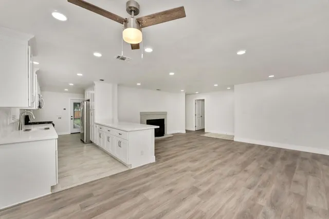 a view of kitchen with kitchen island wooden floor center island and stainless steel appliances