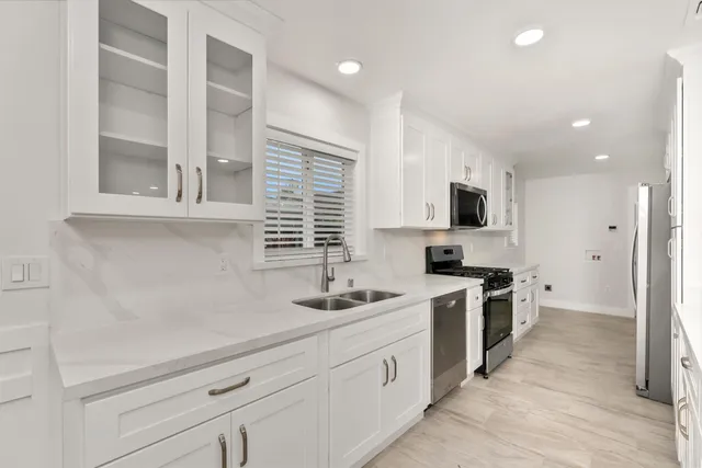 a kitchen with white cabinets and appliances