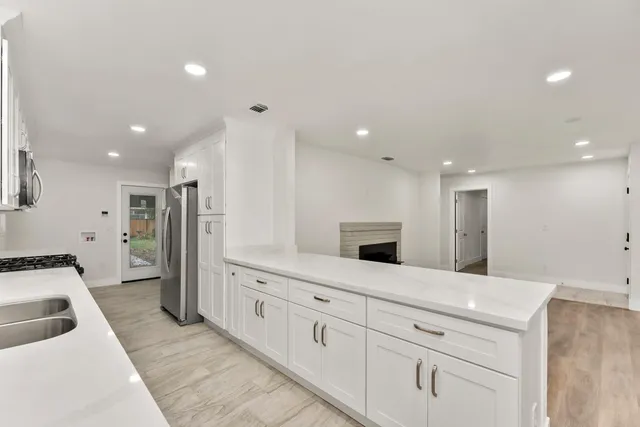 a large white kitchen with stainless steel appliances