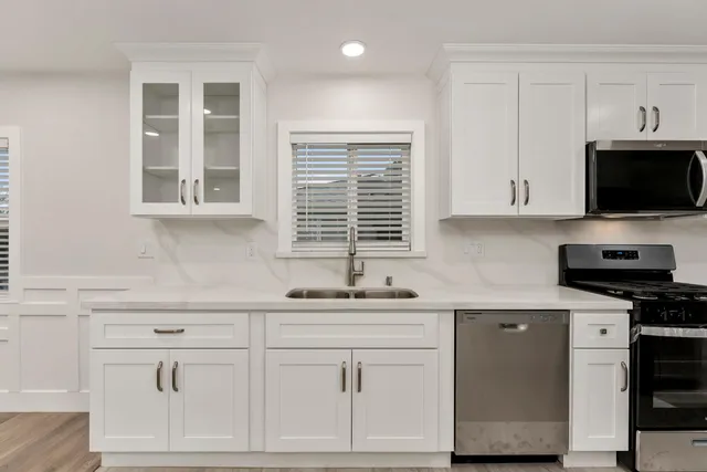 a kitchen with stainless steel appliances white cabinets and a sink