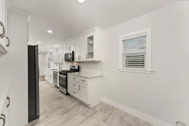 a kitchen with stainless steel appliances granite countertop a stove a sink and a refrigerator