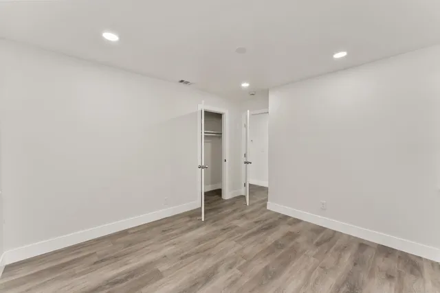 a view of an empty room with wooden floor