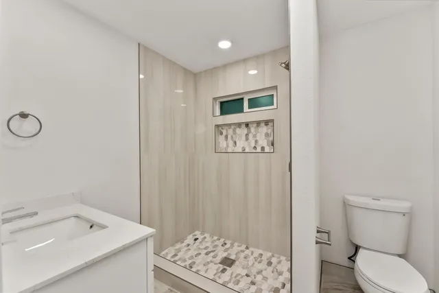 a bathroom with a sink a toilet and a mirror