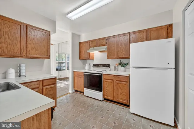 a kitchen with stainless steel appliances granite countertop a refrigerator sink stove and cabinets