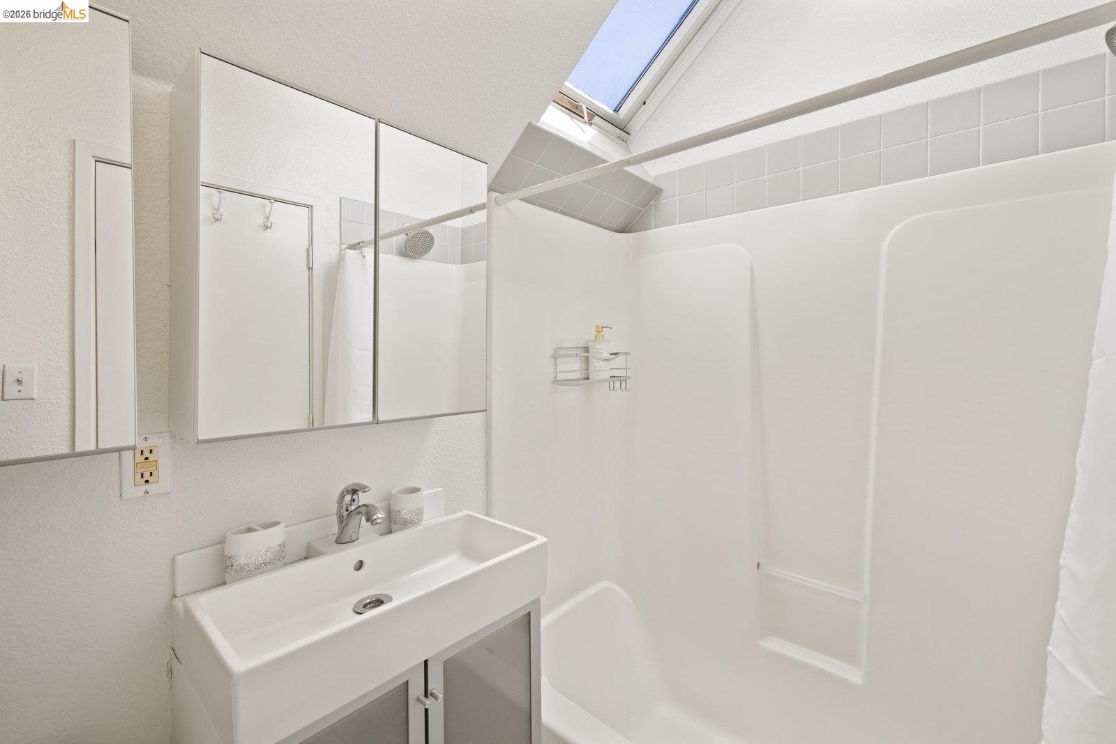 1450 Fourth Street, Unit 5 Berkeley, CA 94710 - Photo 16 of 26 a bathroom with a sink a mirror and a shower