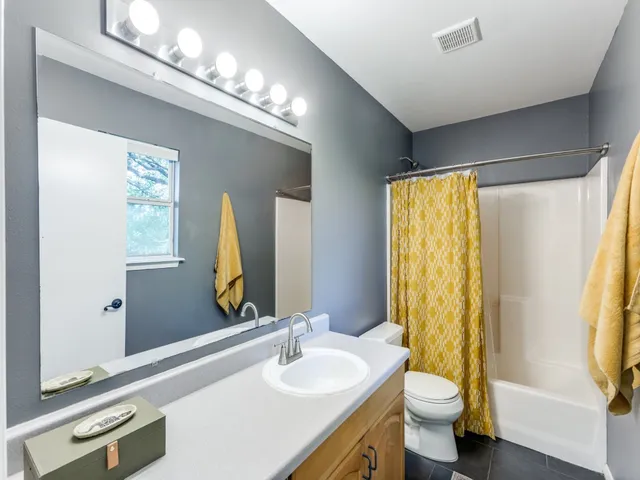 a bathroom with a double vanity sink toilet and a mirror