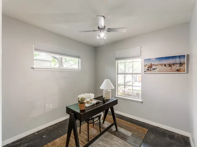 a view of a workspace with furniture and a window