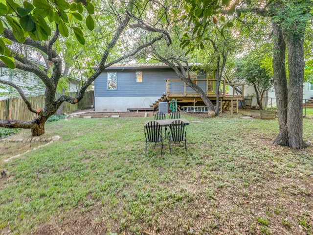 a backyard of a house with table and chairs