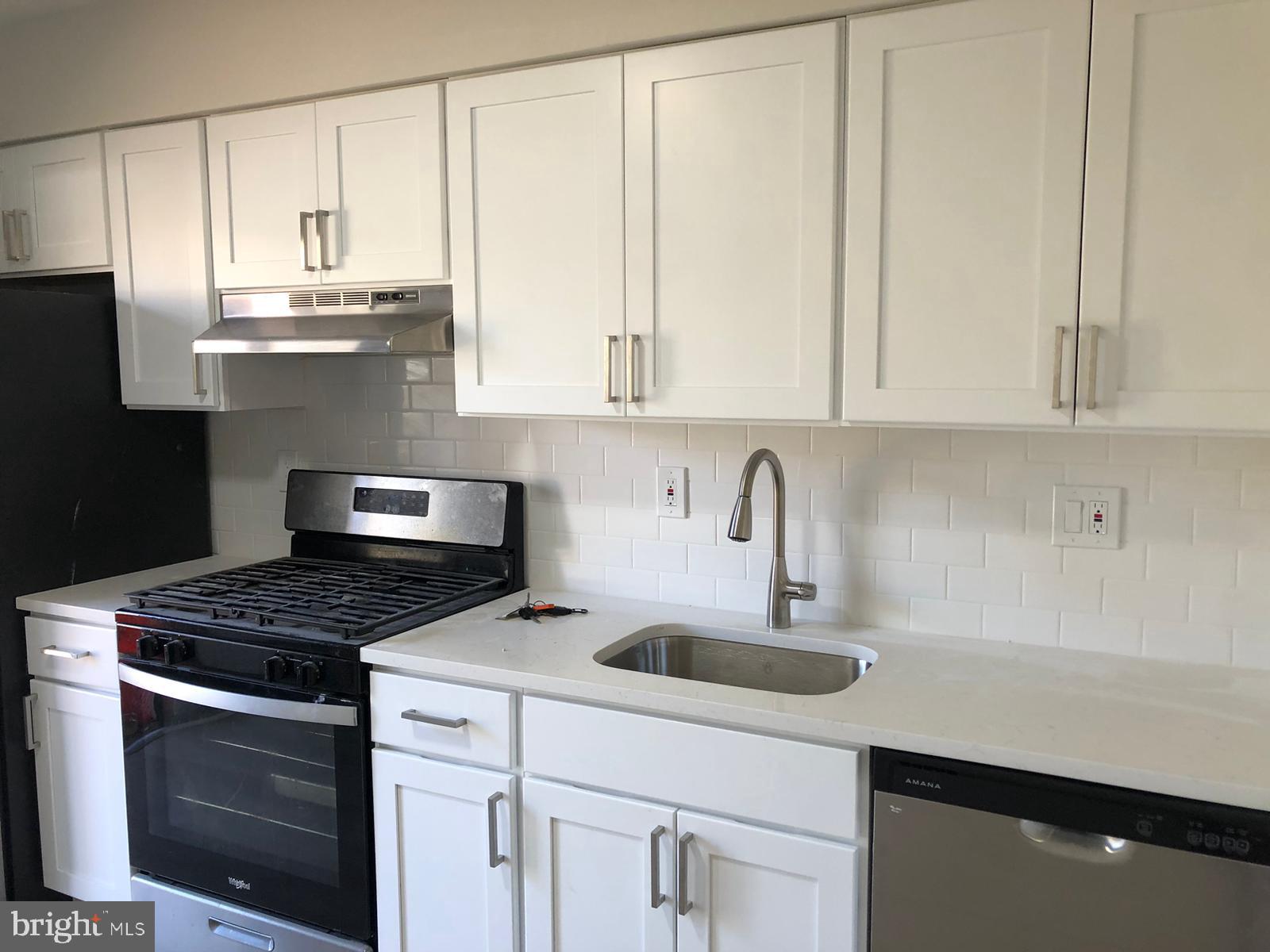 a kitchen with granite countertop white cabinets and sink