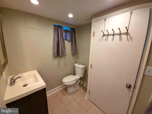 a bathroom with a toilet sink and mirror